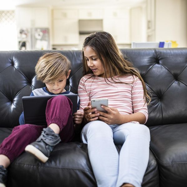 kids using tablet and phone on sofa