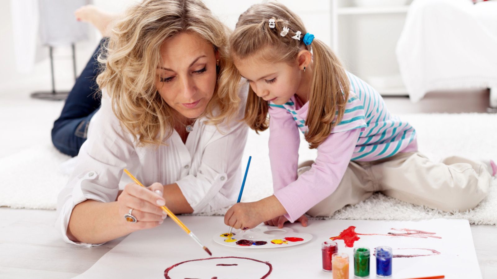 Little girl painting with her mother.jpg