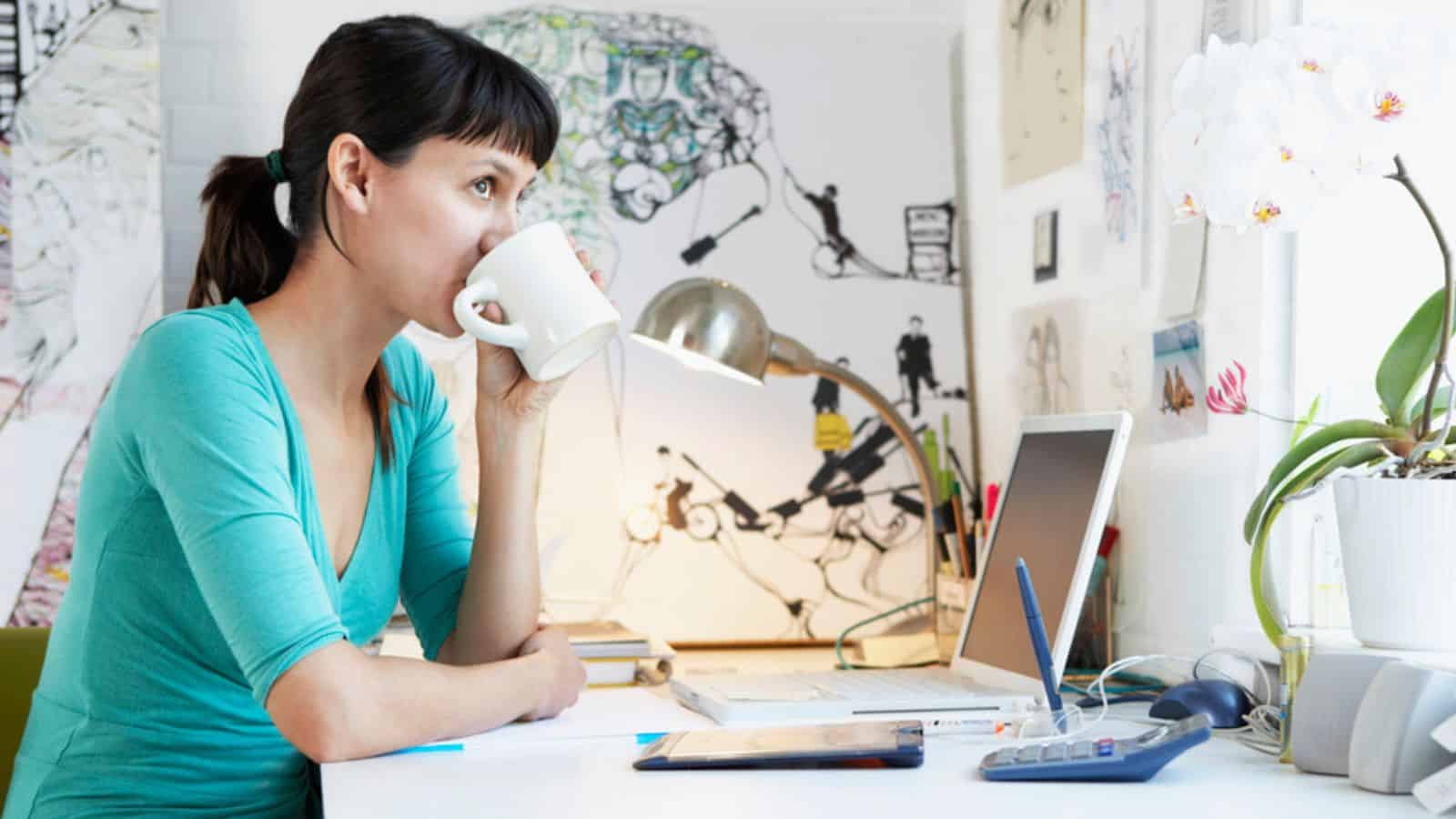 Woman working at a desk while drinking coffee.jpg
